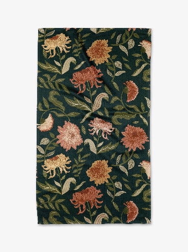 Floral patterned fabric with pink, orange, and green flowers on a dark green background