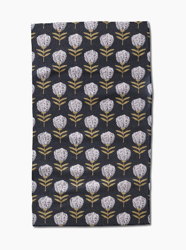 Floral patterned towel with white flowers on a dark background