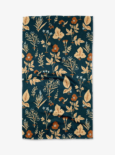 Floral patterned fabric with leaves and flowers on a dark blue background